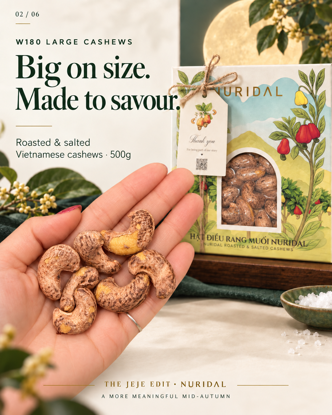 Large W180 skin-on cashews held in a hand beside the NURIDAL 500g gift box.