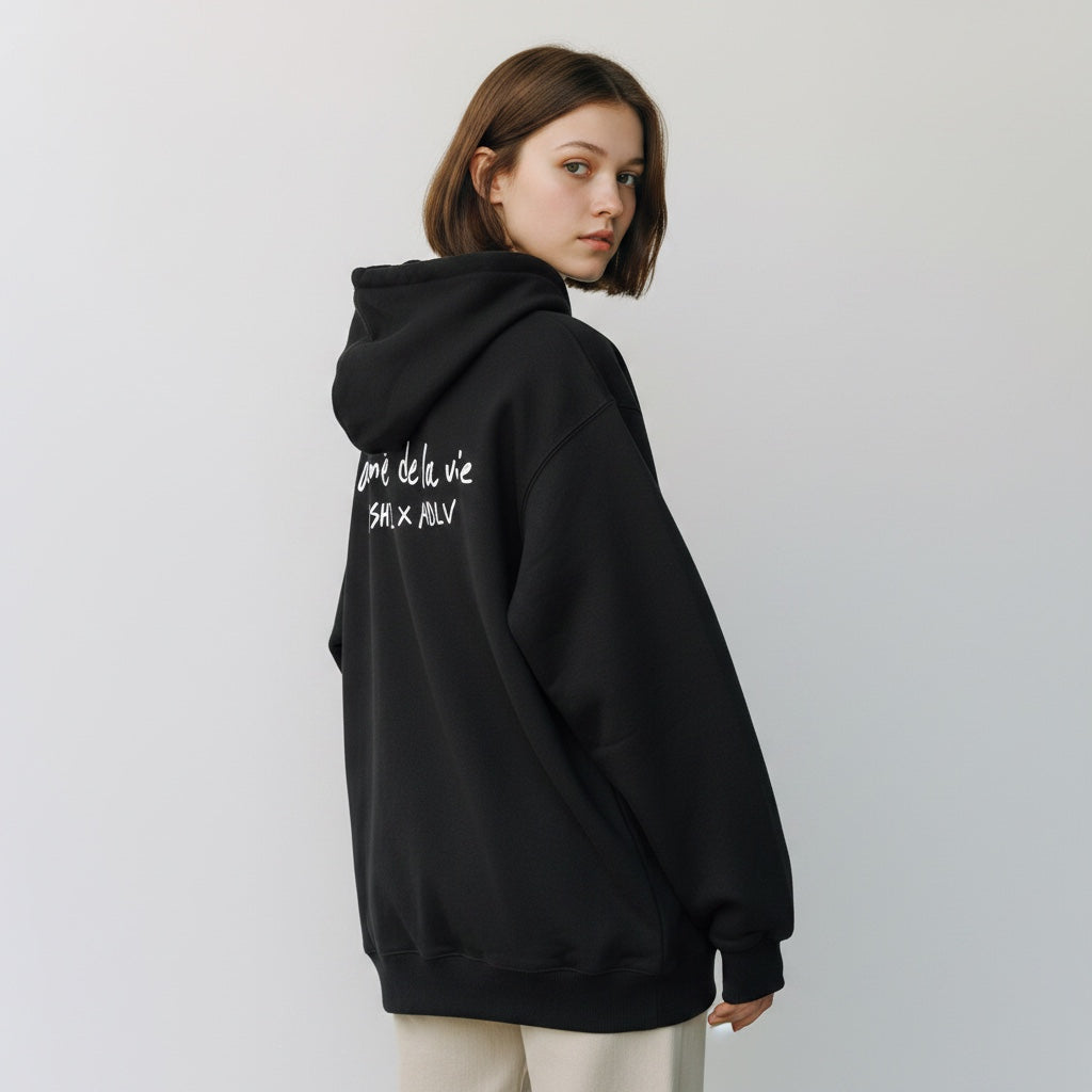 The JeJe Korea fashion&lifestyle ADLV X HOSHI 블랙 코튼 와펜 후드티를 입고 뒤를 돌아보는 모델
