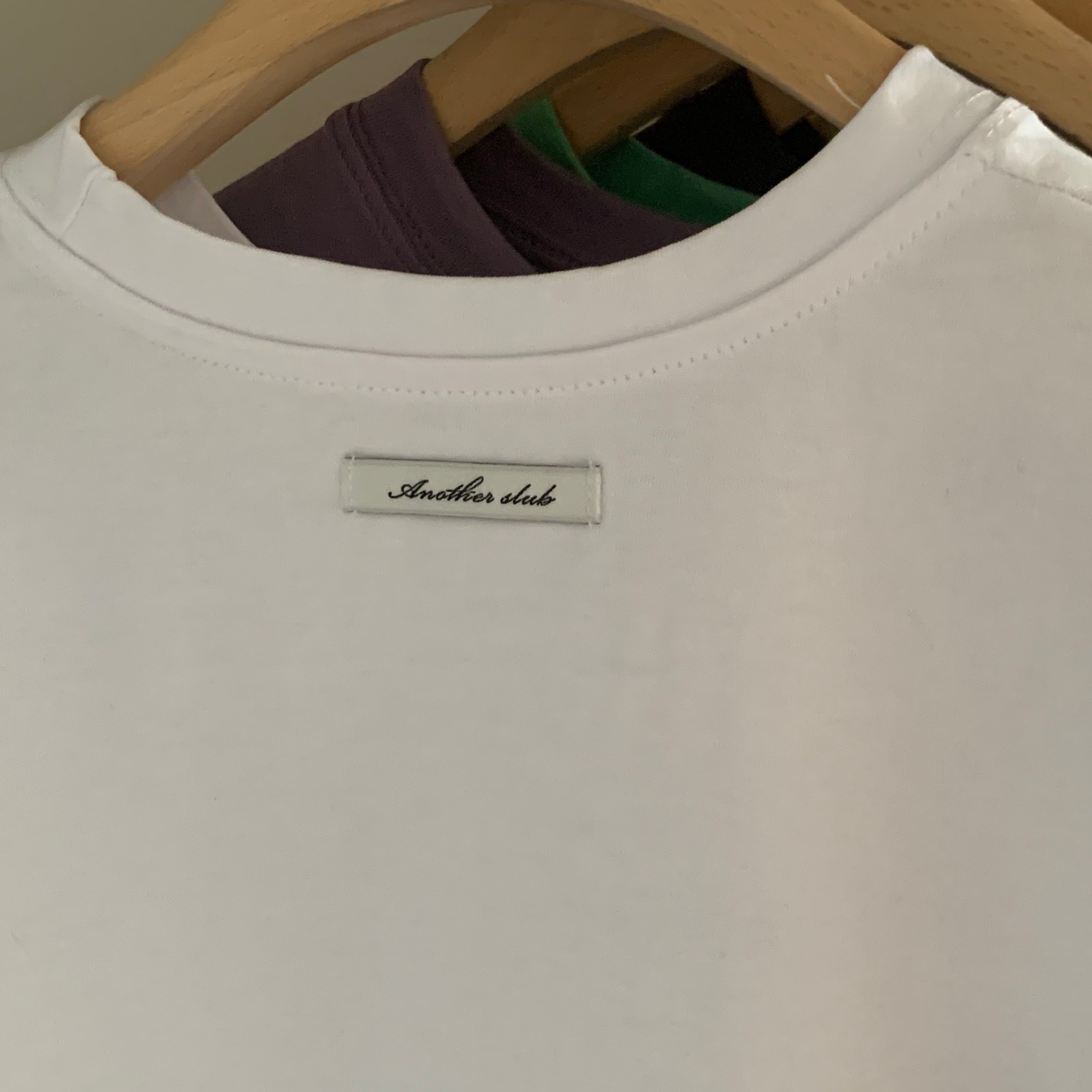 The JeJe Korea fashion&lifestyle 브랜드의 화이트 면 소재 베이직 핏 반팔 티셔츠, 목 뒷부분에 로고 라벨 디테일