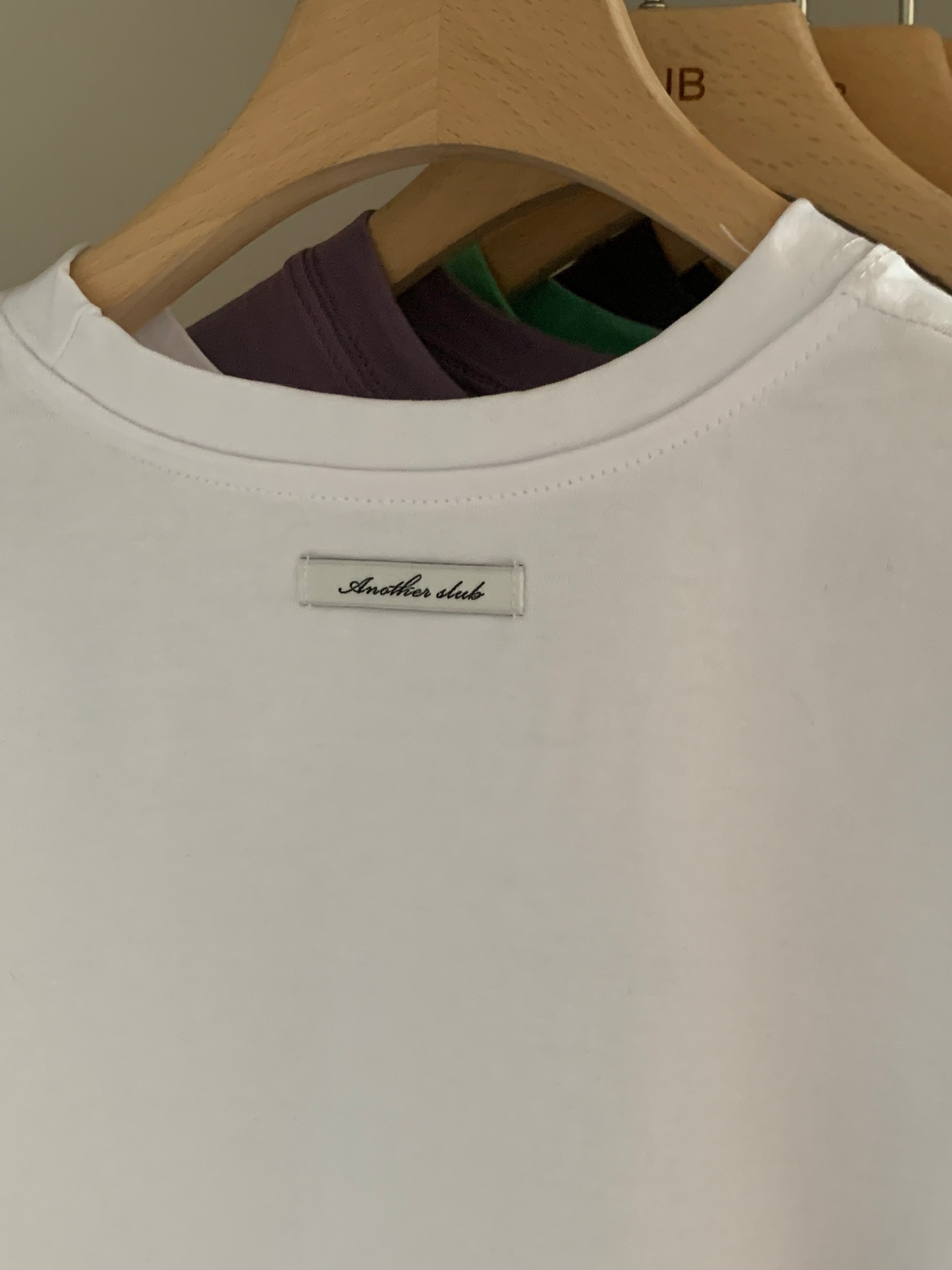 The JeJe Korea fashion&lifestyle 브랜드의 화이트 면 소재 베이직 핏 반팔 티셔츠, 목 뒷부분에 로고 라벨 디테일