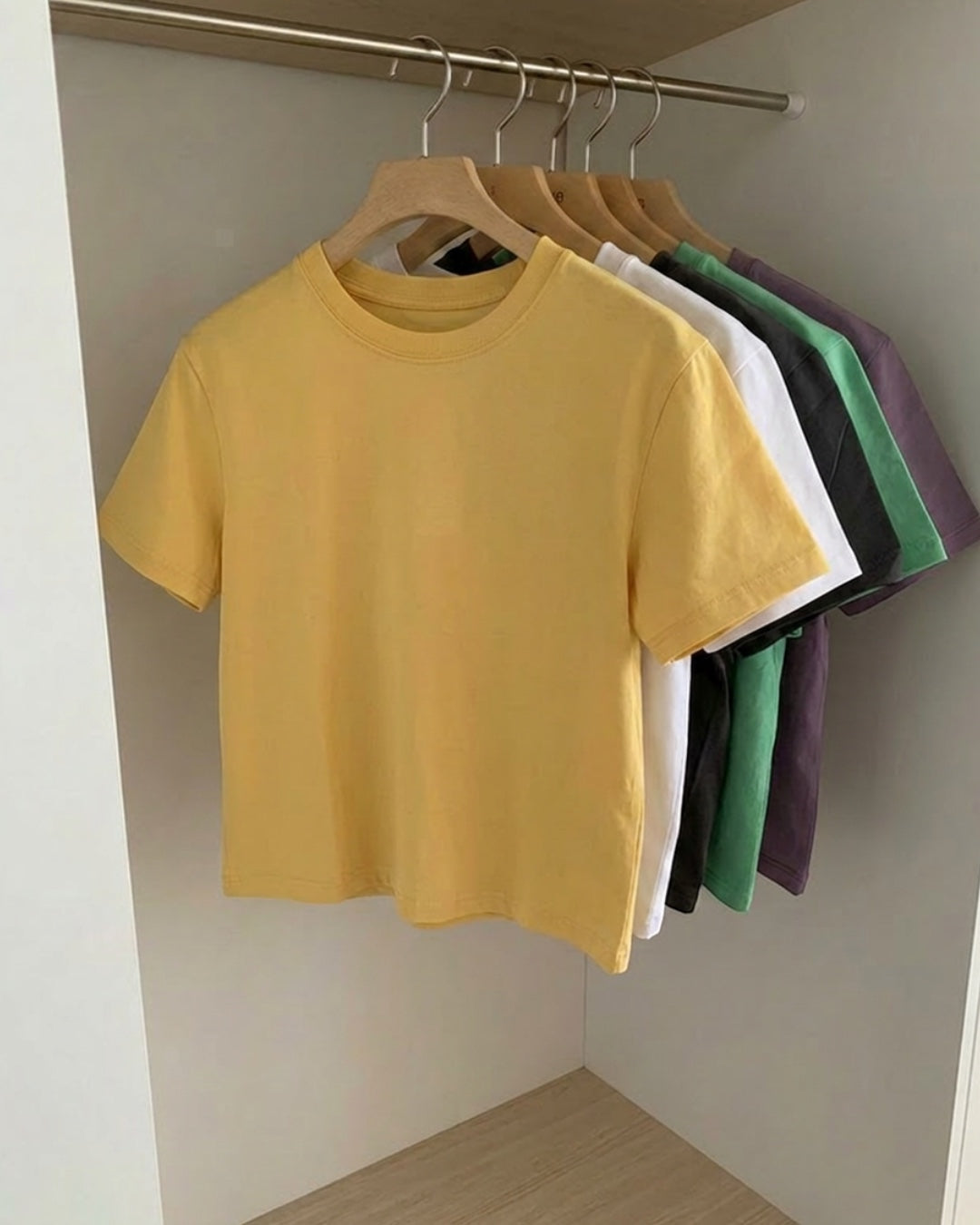 The JeJe Korea fashion&lifestyle의 노란색 면 소재 베이직 핏 반팔 티셔츠가 옷걸이에 걸려 있는 모습
